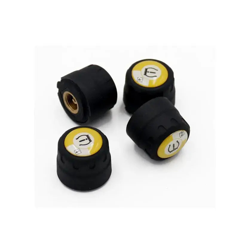 Four black TPMS valve stem caps with yellow labels on a white background